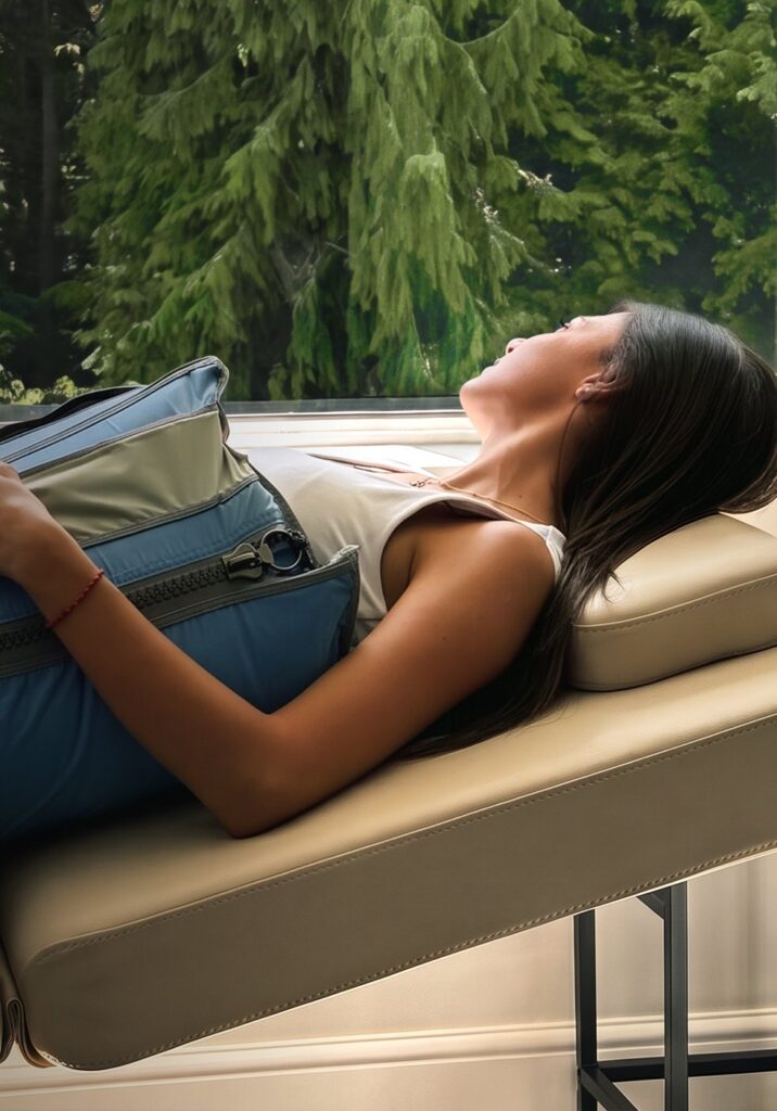 A client relaxing during lymphatic compression therapy by a window overlooking the trees